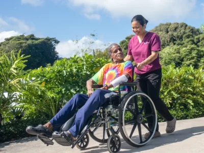 Nurse taking patient outside in wheelchair