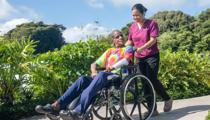 Nurse taking patient outside in wheelchair