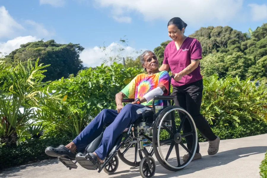 Nurse taking patient outside in wheelchair